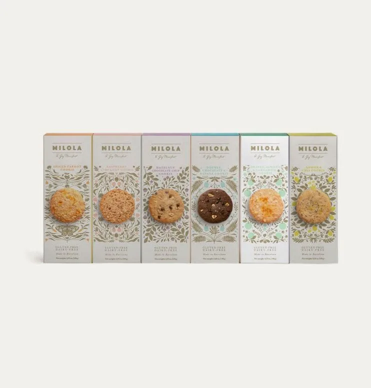Foto de las cajas de los seis sabores de galletas sin gluten de Milola con la de naranja, almendra y cardamomo resaltada.